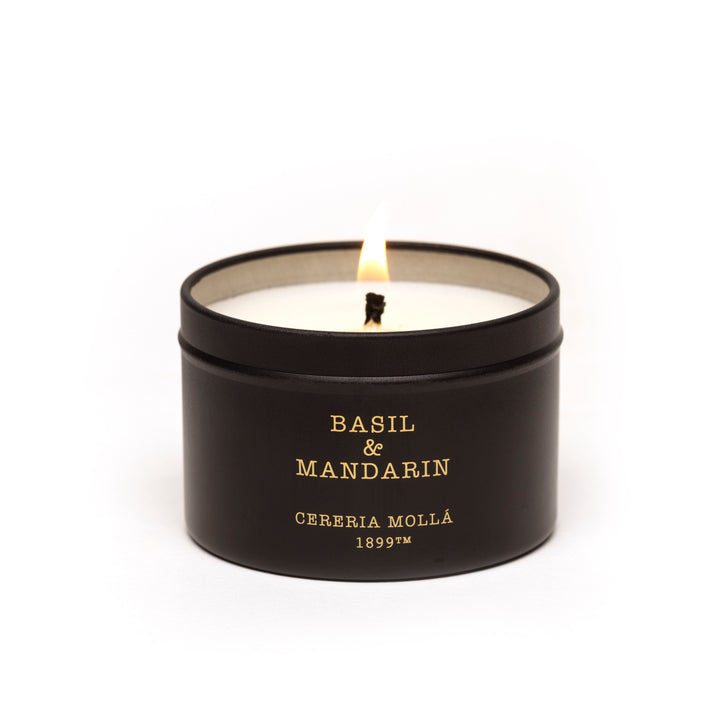 Bougie de voyage parfumée au basilic et à la mandarine dans un récipient en verre noir